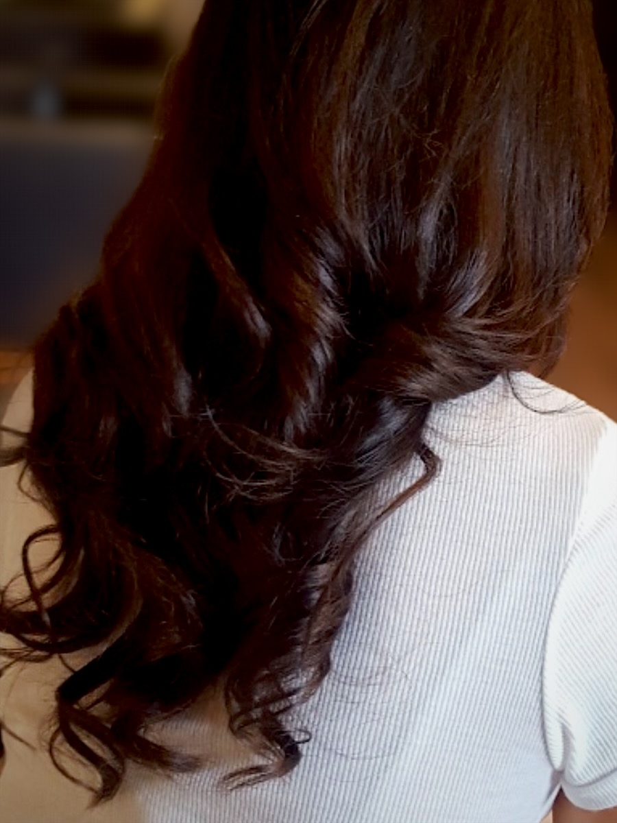 Long, glossy dark-brown hair with soft waves, seen from behind