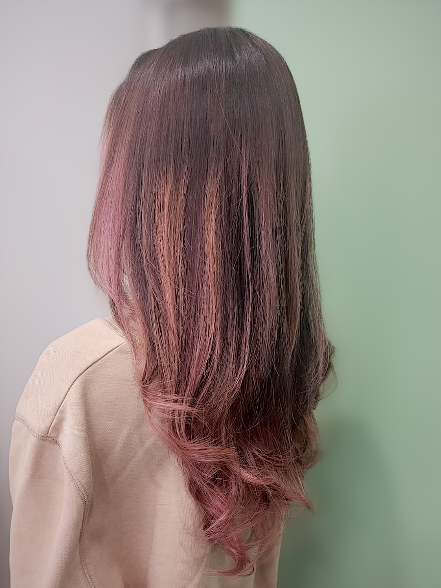 Long dark-brown hair melting into rose-pink lengths with soft curled ends, seen from behind